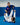 Women in blue and white Gracie Barra kimonos and gi pants working from guard on a blue mat, red Barra Shield patch on the shoulder