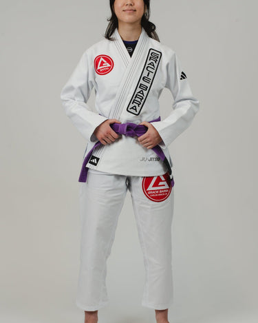 Woman wearing the white adidas Pro Lite Comp Kimono with Gracie Barra branding, standing confidently against a white background.