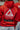Man wearing the Gracie Barra 40 Years Competition Team red zip hoodie inside a Gracie Barra jiu-jitsu school, showing the Red Shield back logo and Jiu-Jitsu graphic