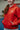 Kid wearing Gracie Barra 40 Years Competition Team red zip hoodie with Red Shield chest logo, standing in a Gracie Barra jiu-jitsu school environment
