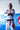White 40 Year Anniversary Kimono, arms crossed; red Barra Shield chest patch, Gracie Barra Patch lapel, black belt with red rank bar, red circular thigh logo.