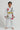 Child wearing a white Pro Lite Comp Youth Kimono by adidas with Gracie Barra branding on a white background