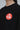 Close-up of the Black Red Shield Elite Womens Crop Tee, highlighting the red Gracie Barra Red Shield emblem on the left chest against a light gray background.