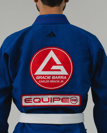 Close-up of back of men's blue Pro Lite Comp Kimono by adidas showing red Gracie Barra and EQUIPE GB patches