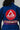 Close-up of the back of a blue Pro Lite Comp Kimono by adidas featuring a prominent red Gracie Barra circular patch and EQUIPE GB branding across the lower back, worn by a woman on a plain background.