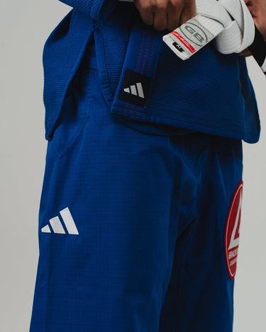 Close-up of right side of blue Pro Lite Comp Kimono by adidas showing white adidas logo and Gracie Barra patch