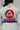 Close-up of the back of a white Pro Lite Comp Kimono by adidas, featuring large Gracie Barra and Equipe GB patches on a plain background.