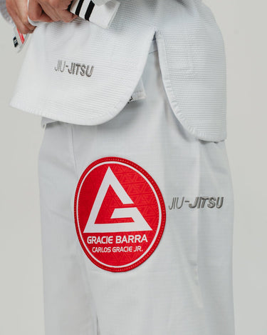 Close-up of left side of Pro Lite Comp Men’s Kimono by adidas in white showing Gracie Barra patch and Jiu-Jitsu embroidery on pants