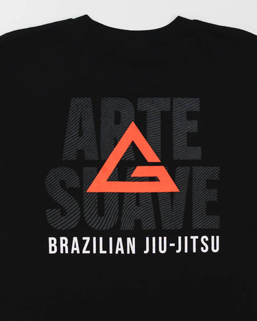 Close-up of the back of the black Arte Suave V2 kids’ T-shirt by Gracie Barra, showcasing a large red Legacy G logo layered over bold black “Arte Suave” text, with “Brazilian Jiu-Jitsu” in white beneath, displayed on a light gray background.
