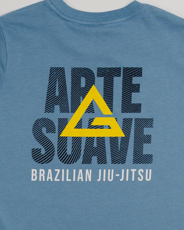 Close-up of the back design on the Arte Suave V2 kids’ T-shirt in blue by Gracie Barra, featuring large black “Arte Suave” text with a yellow Legacy G logo overlay and “Brazilian Jiu-Jitsu” in white beneath, displayed on a light gray background.