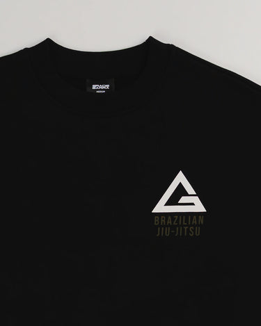 Close-up of black Arte Suave V2 men’s crewneck sweatshirt in French terry by Gracie Barra, featuring white Legacy G chest logo with “Brazilian Jiu-Jitsu” text.