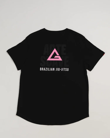 Back view of the Arte Suave V2 women’s black T-shirt featuring a large pink Legacy G logo above “BRAZILIAN JIU-JITSU” text, with subtle “ARTE SUAVE” lettering in the background, displayed on a light gray backdrop.