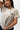 Arte Suave V3 Womens Tee in natural, three-quarter front close-up showing the chest print: black Legacy G logo above white 'Arte Suave' script.