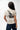 Arte Suave V3 Womens Tee in natural, three-quarter back view. Full-back print: white 'Arte Suave' script, black tonal figure, white 'Gracie Barra' wordmark.