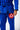 Light blue Competition embroidery on the jacket skirt of the blue AtletaGB V5 CompLite Kimono, with the belt knot and red Gracie Barra pant patch.