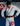 Gracie Barra professor wearing the white AXIS Kimono by adidas tying a black belt on blue mats inside a Gracie Barra school.