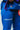 Close-up of blue Atleta competition gi pants worn with a purple belt, showing the white Competition thigh print, Gracie Barra patch and Atleta jacket label