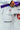 Close-up of white Atleta competition gi pants worn with a purple belt, showing the Competition thigh print, red Gracie Barra patch and Atleta jacket label