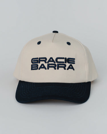 Front view of Barra Cap in natural color with navy brim and raised navy embroidery reading “Gracie Barra” across the crown.