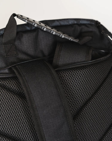 Close-up of back panel on Black Barra da Tijuca Backpack showing padded mesh texture, hidden zipper pocket, and top handle with calçadão-patterned grip.