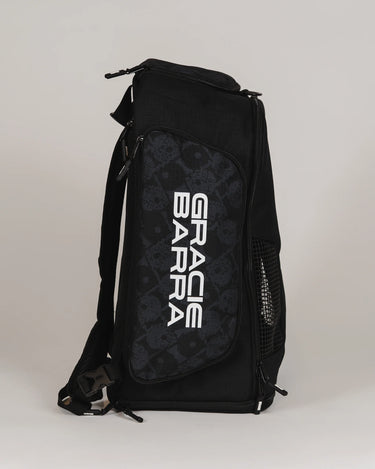 Side view of Black Barra da Tijuca Backpack showing the “Gracie Barra” wordmark over the patterned calçadão fish print panel, with mesh ventilation pocket and ripstop fabric.