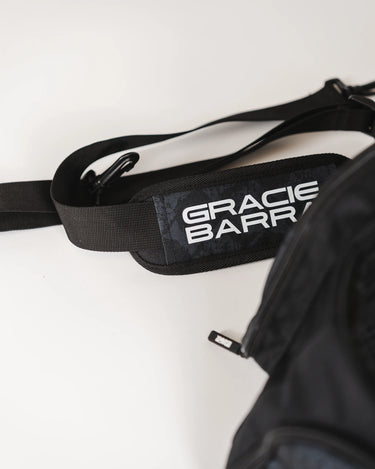 Close-up of Black Barra da Tijuca Backpack duffel strap featuring “Gracie Barra” logo print and adjustable clips for shoulder carry.
