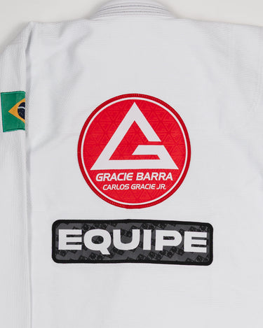 Back view of the Barra da Tijuca White Kimono jacket showing the large Red Shield logo and the EQUIPE patch, with the Brazilian flag patch on the shoulder.