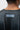 ESTD 1986 print in a gray box below the back collar of the black Barra da Tijuca Terra Mar tee, shown from behind on a student.