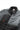 Angled close-up of the men’s black BarraTec fleece jacket showing the grid fleece upper body and sleeves, quilted insulated lower panel, full-length YKK zipper, zippered chest pocket, and padded collar with Gracie Barra interior label.