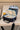 Open black Barra Beachwalk Gracie Barra kids lunchbox with the Barra da Tijuca boardwalk print, gray insulated lining, mesh lid pocket, and packed lunch.