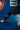 Close-up of the red Barra Shield on the lower leg of the black Close Contact compression pants during a stretch on the blue mat.