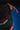 Student adjusting the red GRACIE BARRA waistband of the black Close Contact womens compression pants on a blue mat.