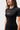 Three-quarter front view of the black Close Contact Womens Rashguard showing the orange chest logos, raglan sleeve seams and short sleeves.