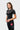 Three-quarter view of the black Close Contact Womens Rashguard with the orange triangle logo, stacked chest wordmark and gray striped side panel.