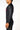Side profile of the black Continuum longsleeve rashguard worn, tonal green Vanguard print down the sleeve and flatlock side seam from shoulder to cuff
