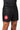 Worn three-quarter view of the black Continuum No Gi Shorts by VG with the red Barra Shield patch and curved hip panel seam.