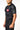 Angled view of the black Gracie Barra Continuum Rashguard by VG showing the tonal green Vanguard sleeve print and tonal Legacy G at the center chest.