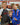 Three young Gracie Barra students celebrating together, two in Gracie Barra rashguards and a blue kimono, the youngest wearing a CompNet medal.