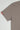 Close-up of the sleeve of a warm grey Gracie Barra t-shirt, featuring the red Gracie Barra sleeve tag against a light background.