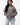 Emblem Womens Hoodie in Gray — full front view on model styled with light-wash jeans, showing the relaxed oversized fit and tonal chest emblem.