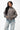 Emblem Womens Hoodie in Gray — full front view on model styled with light-wash jeans, showing the relaxed oversized fit and tonal chest emblem.