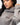 Emblem Womens Hoodie in Gray — close-up on model showing the tonal Gracie Barra chest emblem, hood, and dropped-shoulder sleeve.
