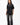 Emblem Womens Tee, black — full-length front view, relaxed oversized fit with tonal embroidered Gracie Barra chest emblem, styled with jeans and sneakers.