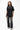 Emblem Womens Tee, black — full-length front view, relaxed oversized fit with tonal embroidered Gracie Barra chest emblem, styled with jeans and sneakers.