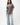 Emblem Womens Tee, grey — full-length front view, relaxed oversized fit with burgundy embroidered Gracie Barra chest emblem, styled with light-wash jeans and white sneakers.