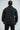 Back view of the black Gracie Barra Equipe windbreaker worn by a model, showing the plain back panel and raglan shoulder seams.