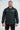 Model wearing the black Gracie Barra Equipe button down windbreaker, front view, with white EQUIPE chest print and red metal clip buttons.