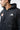 Upper chest of the black Equipe Zip Hoodie showing the full-zip front, drawcords, white adidas logo and red Gracie Barra Barra Shield.