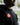 Close-up of model wearing black adidas Gracie Barra hoodie featuring red Barra Shield logo on chest, outdoors setting