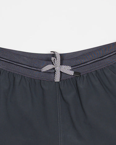 Close-up of the Equipe Motion Men’s Shorts in grey, showing the elastic waistband with reinforced stitching and flat drawstring with silicone tips for secure fit.